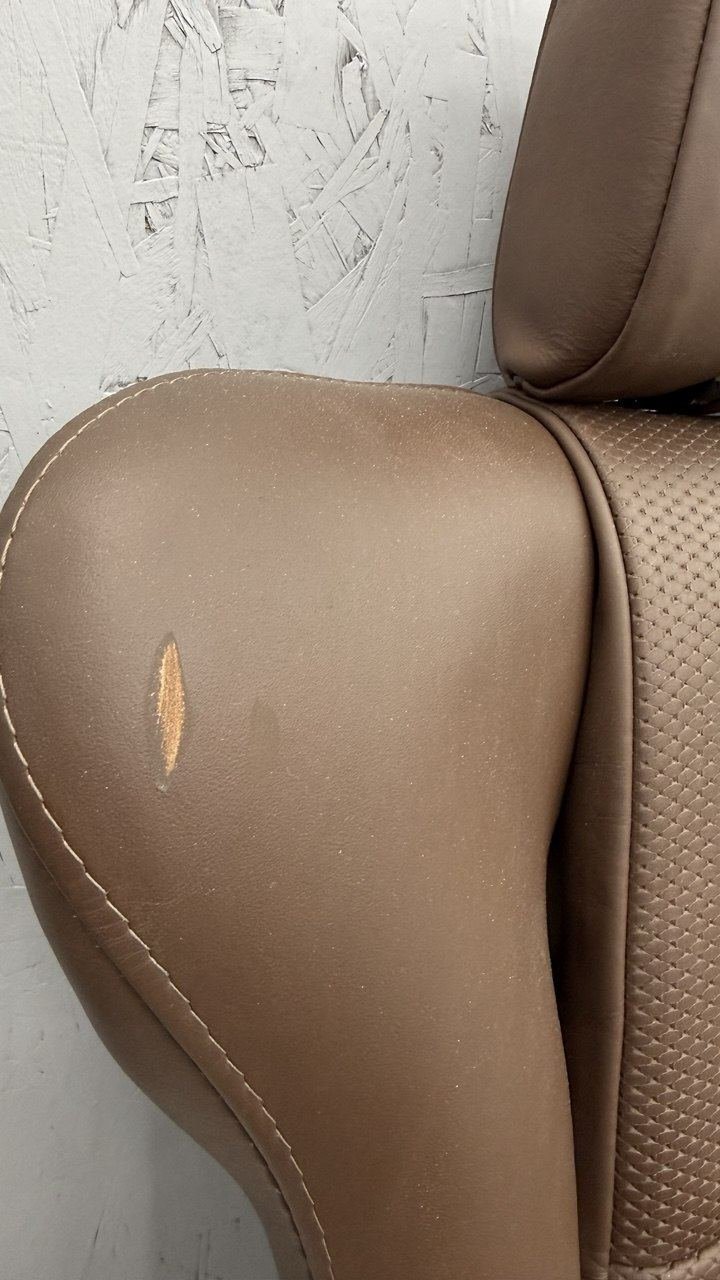 Tan seat bolster with a tear through the leather