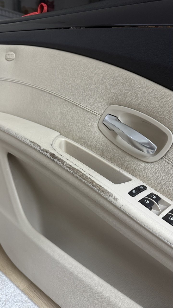 Cream door card, dirt along the armrest edge