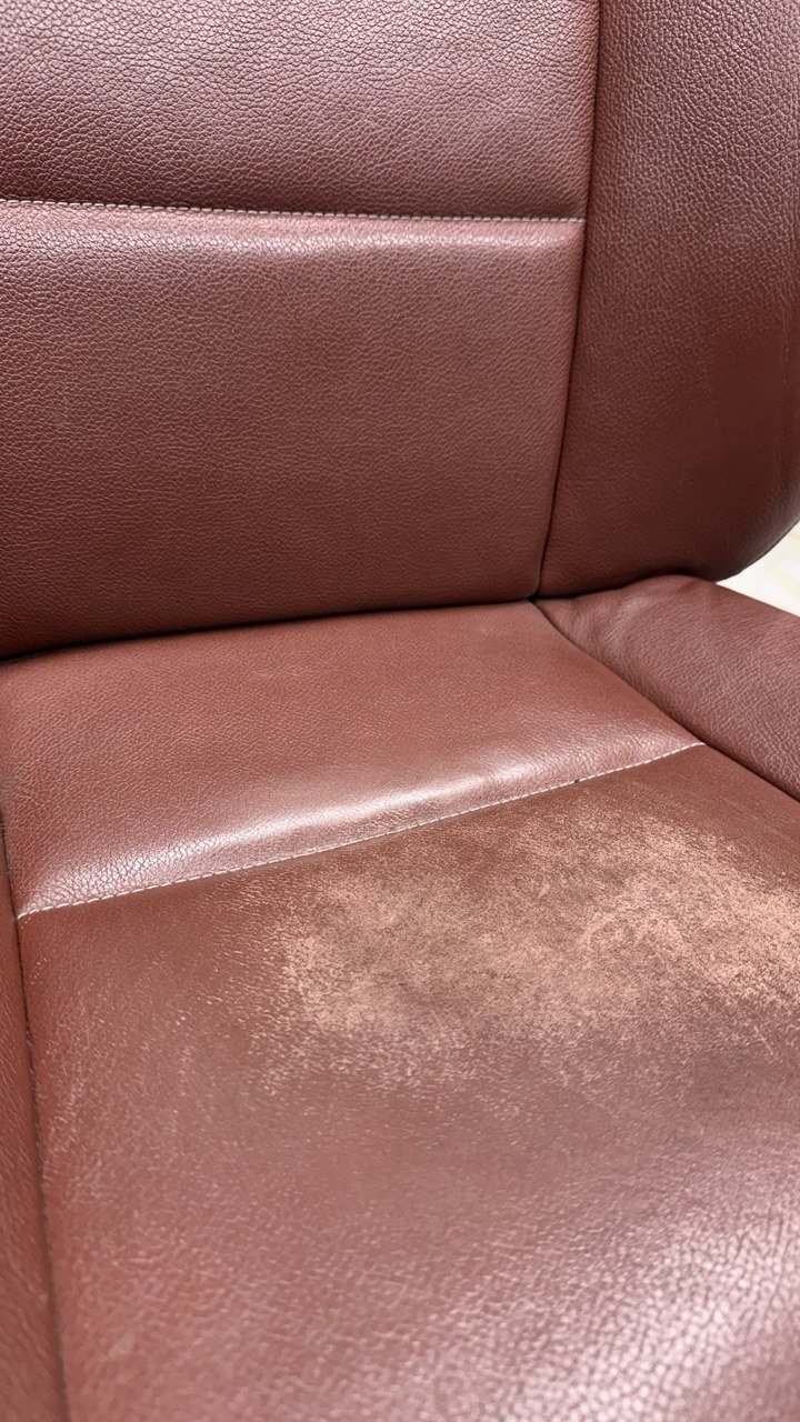 Burgundy seat, faded and rubbed on the cushion