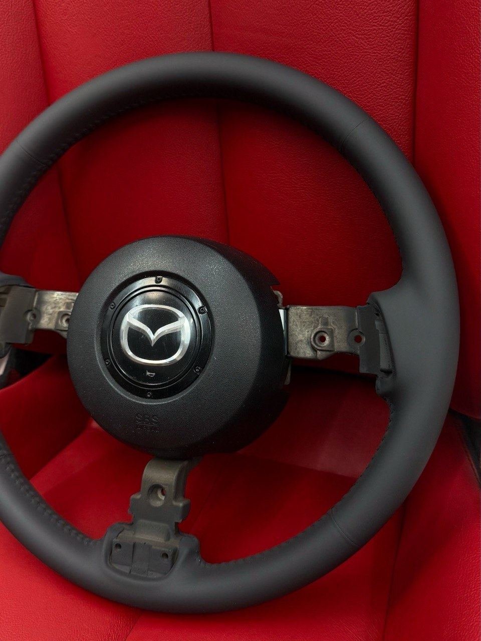 A Mazda steering wheel, reupholstered in black leather